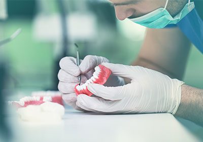 dentist inspecting false teeth